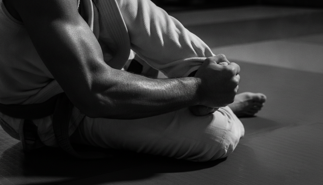 Black and white documentary close-up of a BJJ practitioner's grip on a gi during a mat scramble